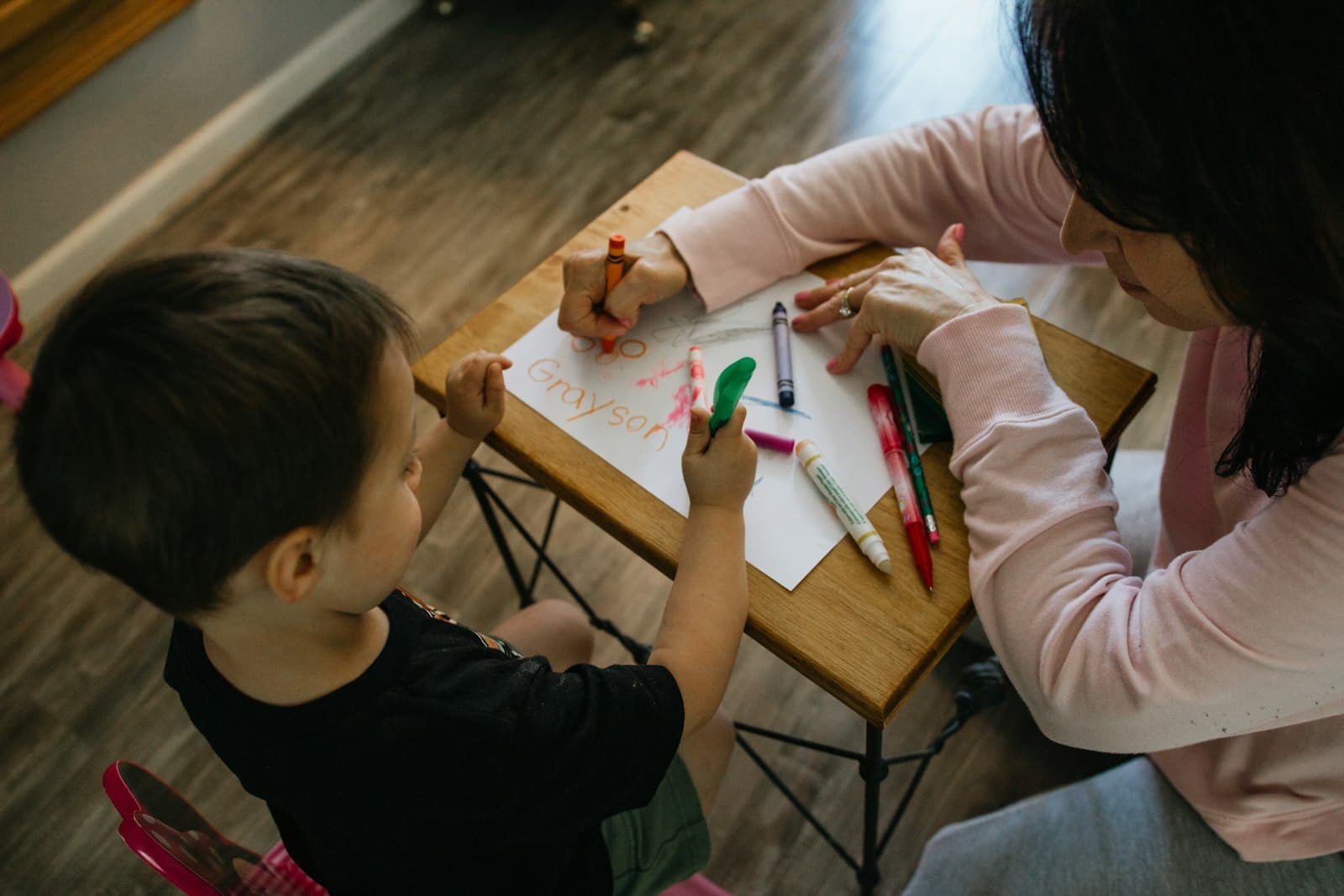 Two children coloring together at a table
