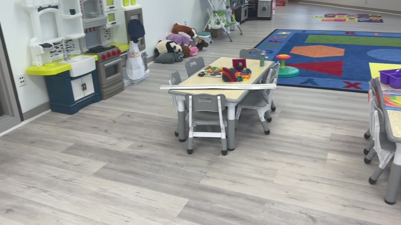 A K+3 classroom with a play kitchen and small tables