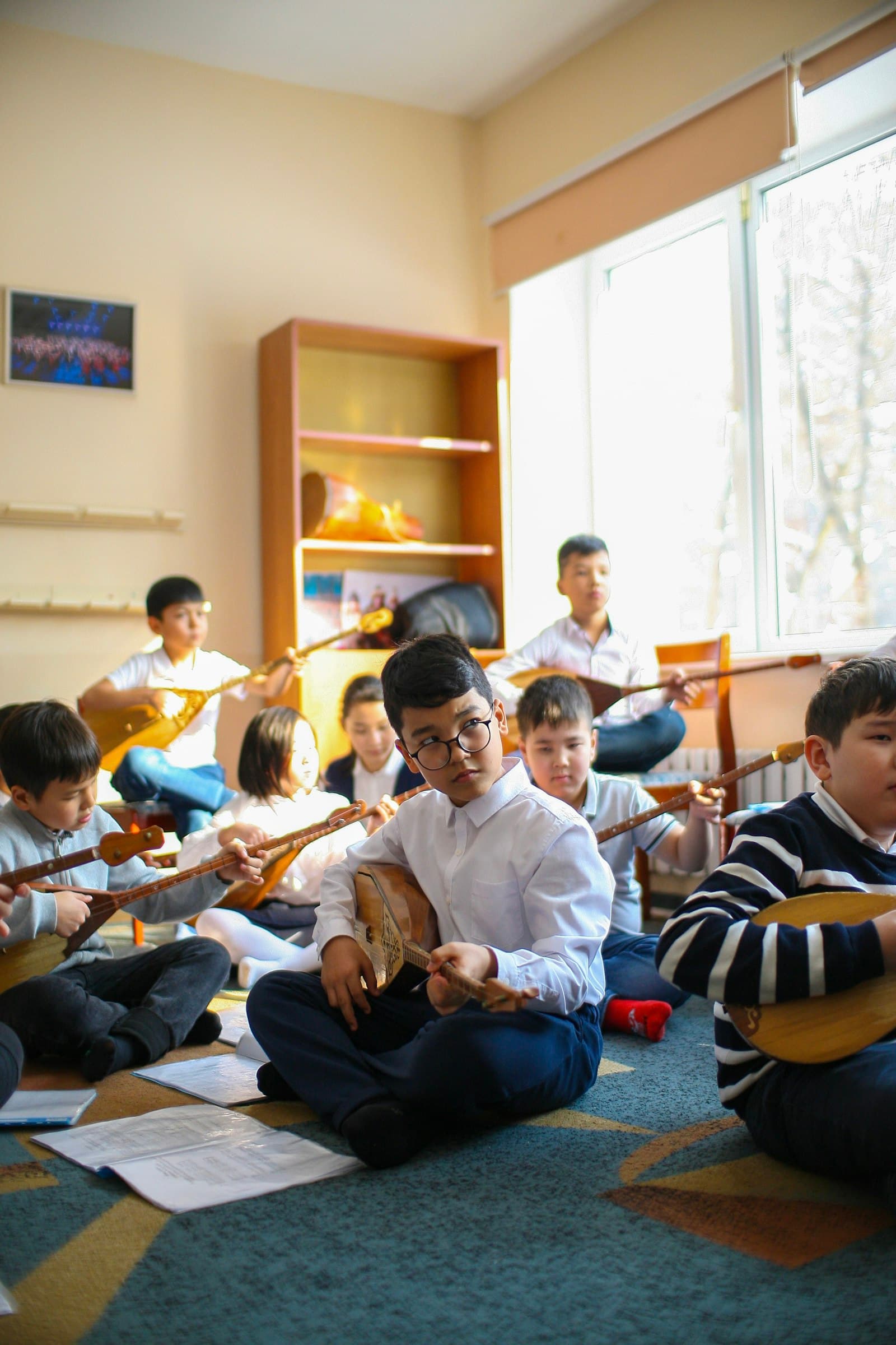 Children sitting on the floor playing small instruments