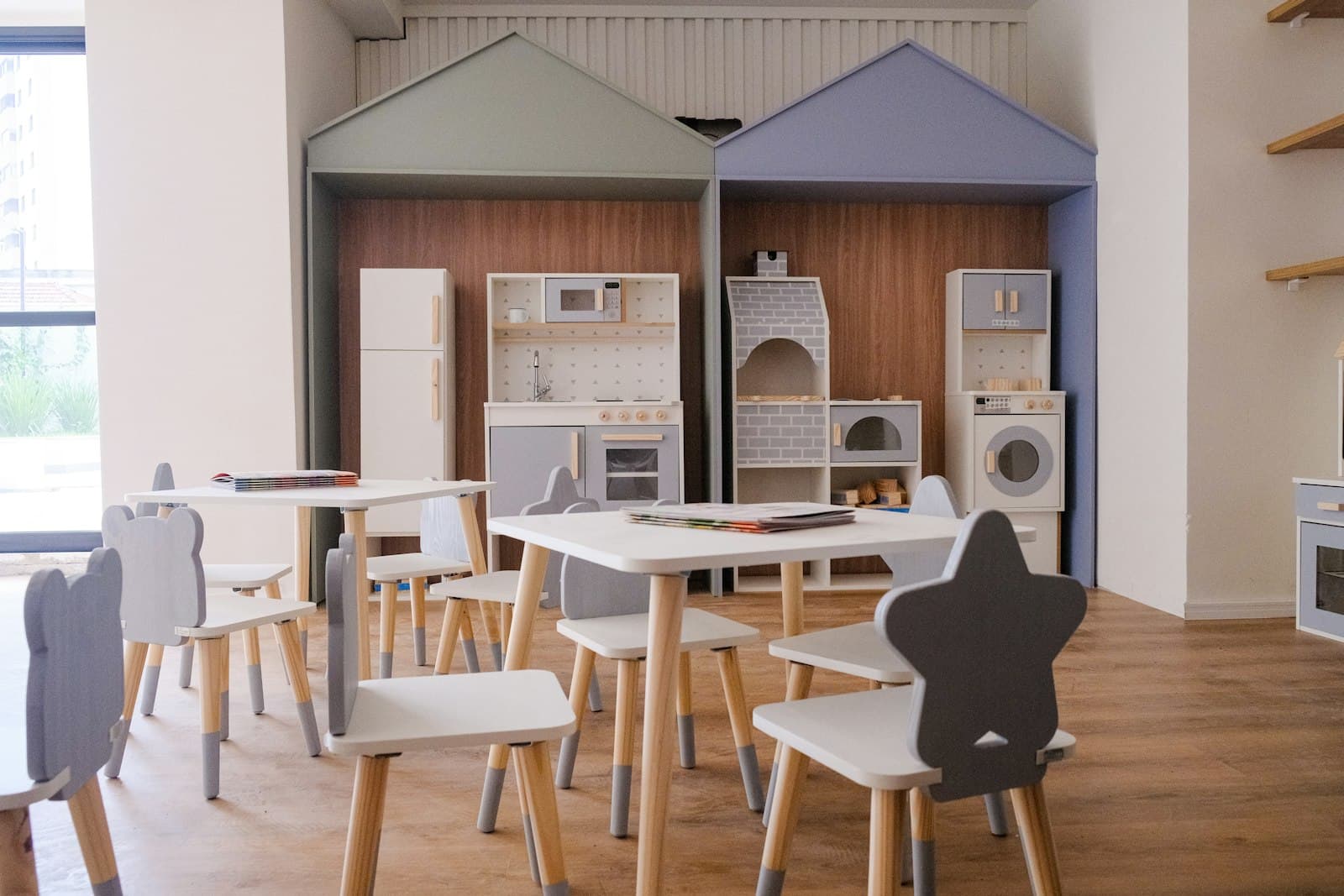 A dramatic play area with a play kitchen and small chairs
