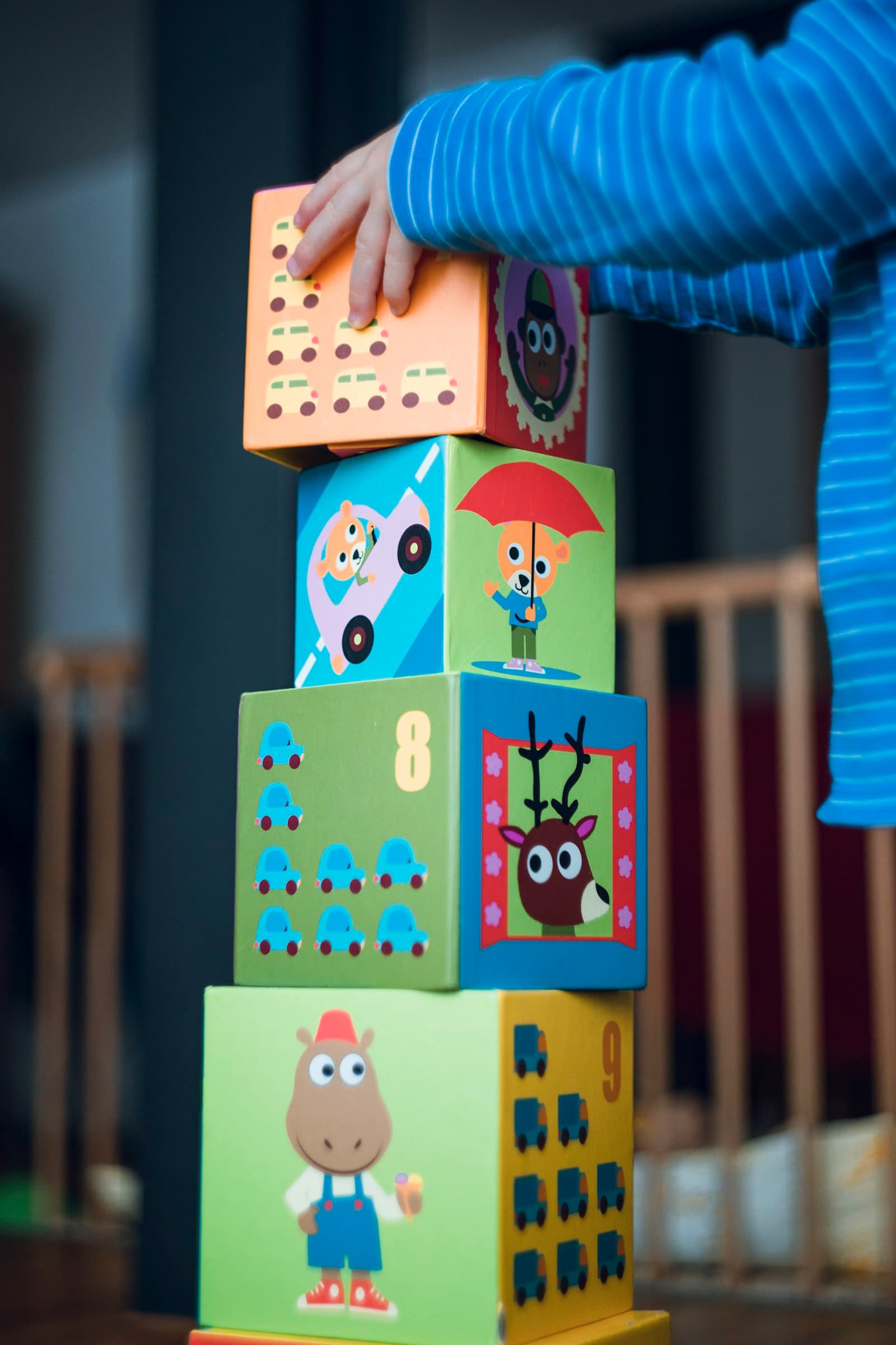 A child stacking cardboard blocks with animal pictures