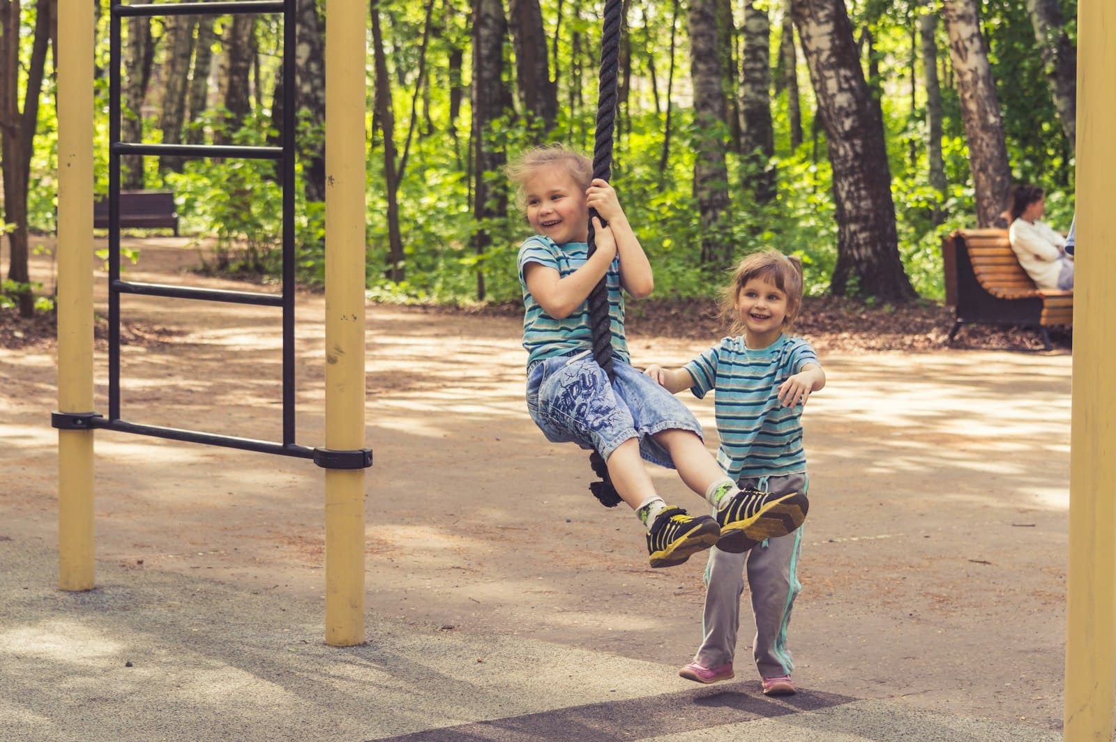 Two children playing on a swing outdoors