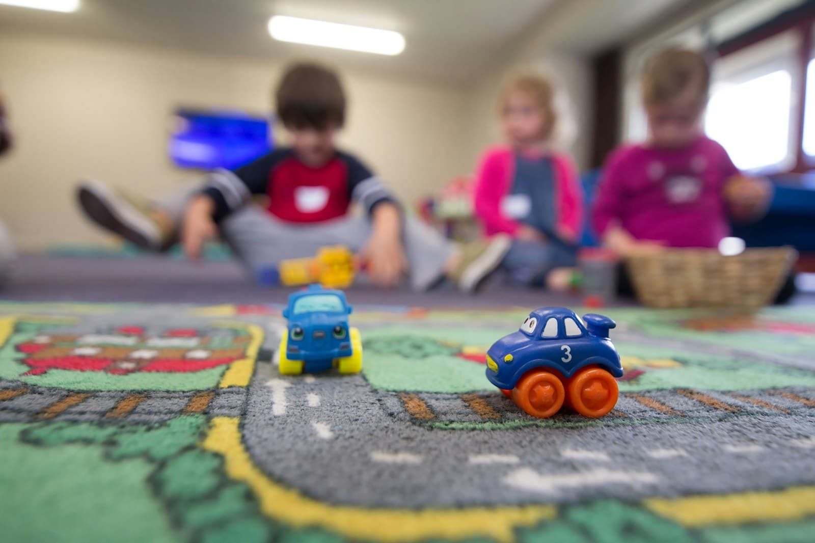Preschool children playing with toys together on the floor